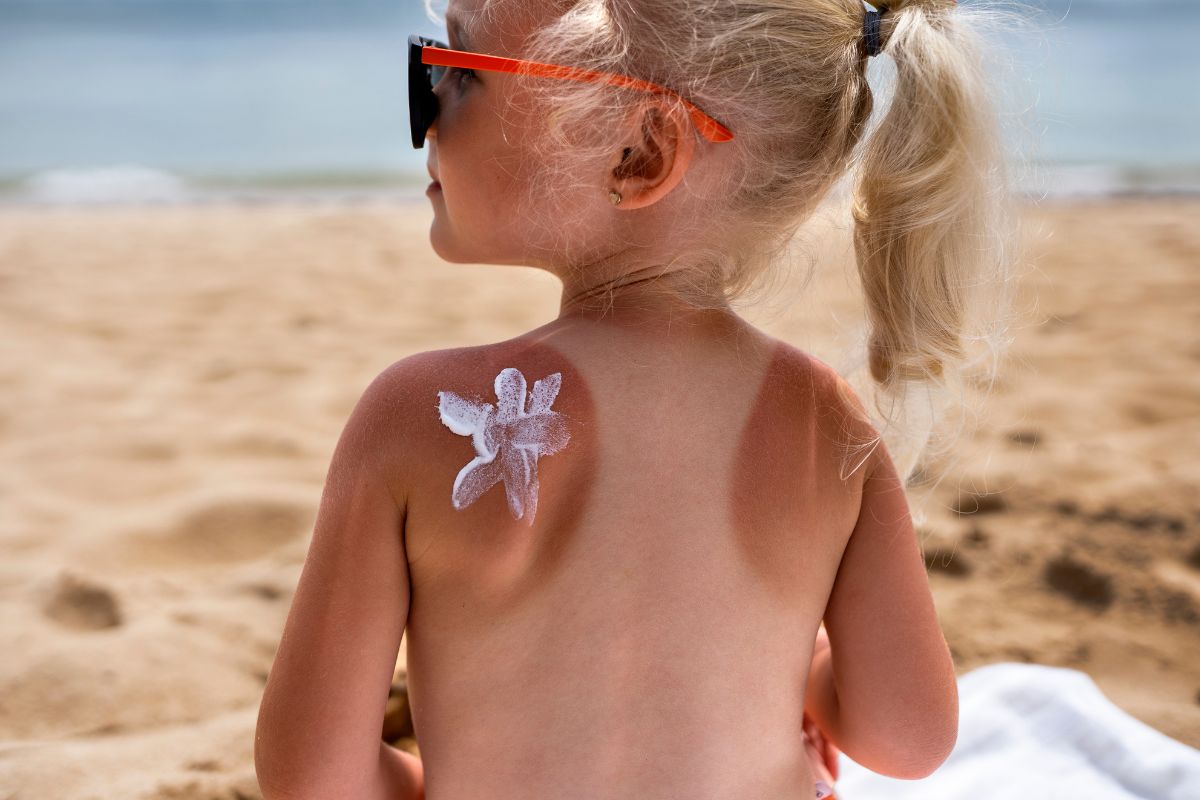 Dijete na plaži s zaštitom dječje kože od UV zračenja